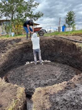 people working on the base of the first tank of the vermicompost system