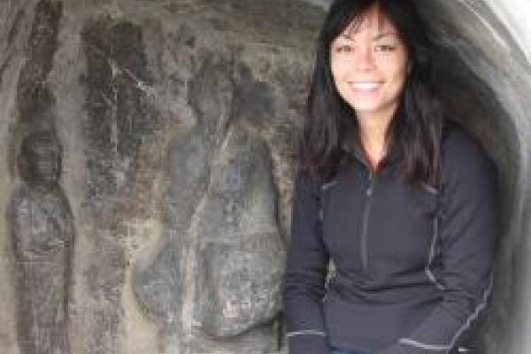 Namiko Kunimoto, a woman sitting on a rock looking at the camera