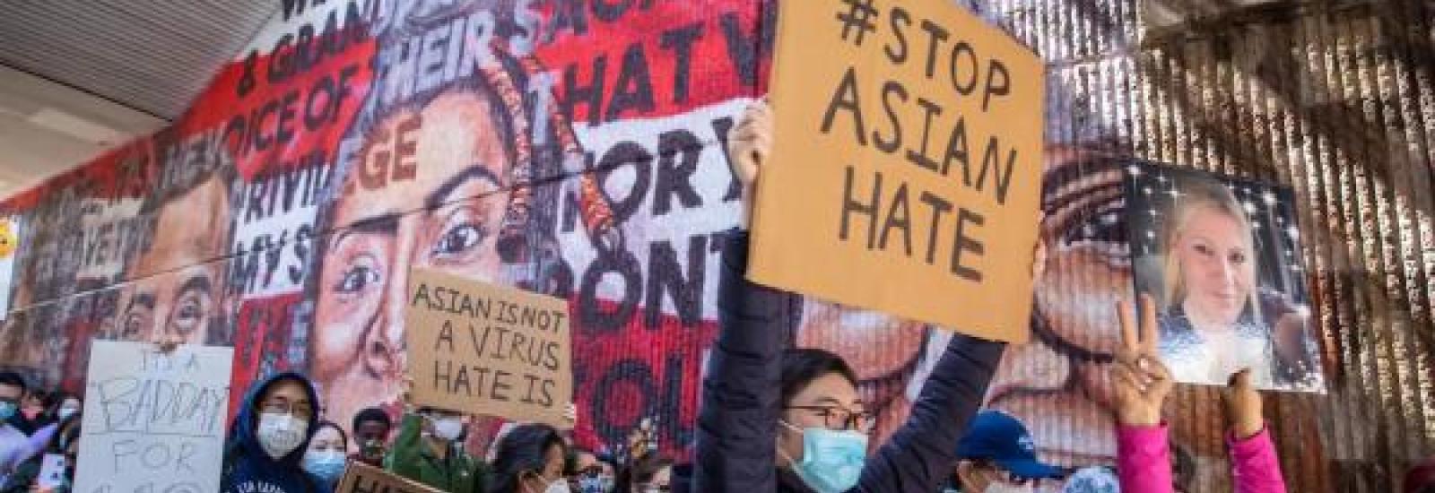 Image of people with signs that say stop Asian hate